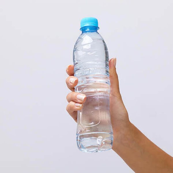 Bouteille d’eau en verre sur une table lumineuse avec une lumière douce